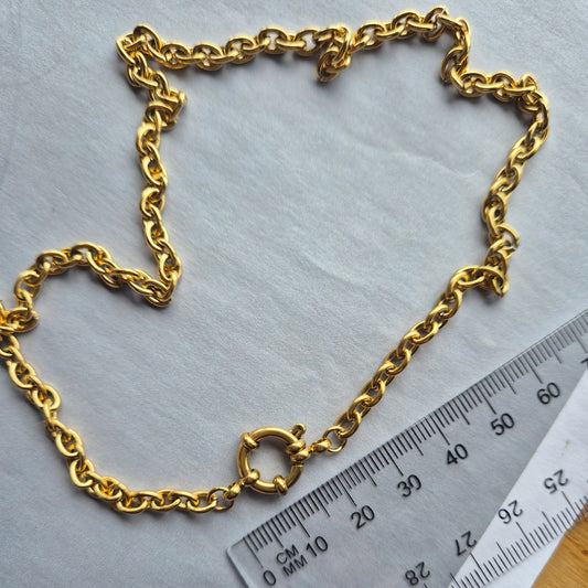 Sorella of May Nera O chain gold necklace beside a ruler