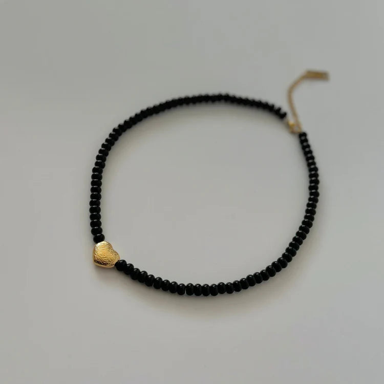 Namaste black beaded maira necklace on plain backgraound