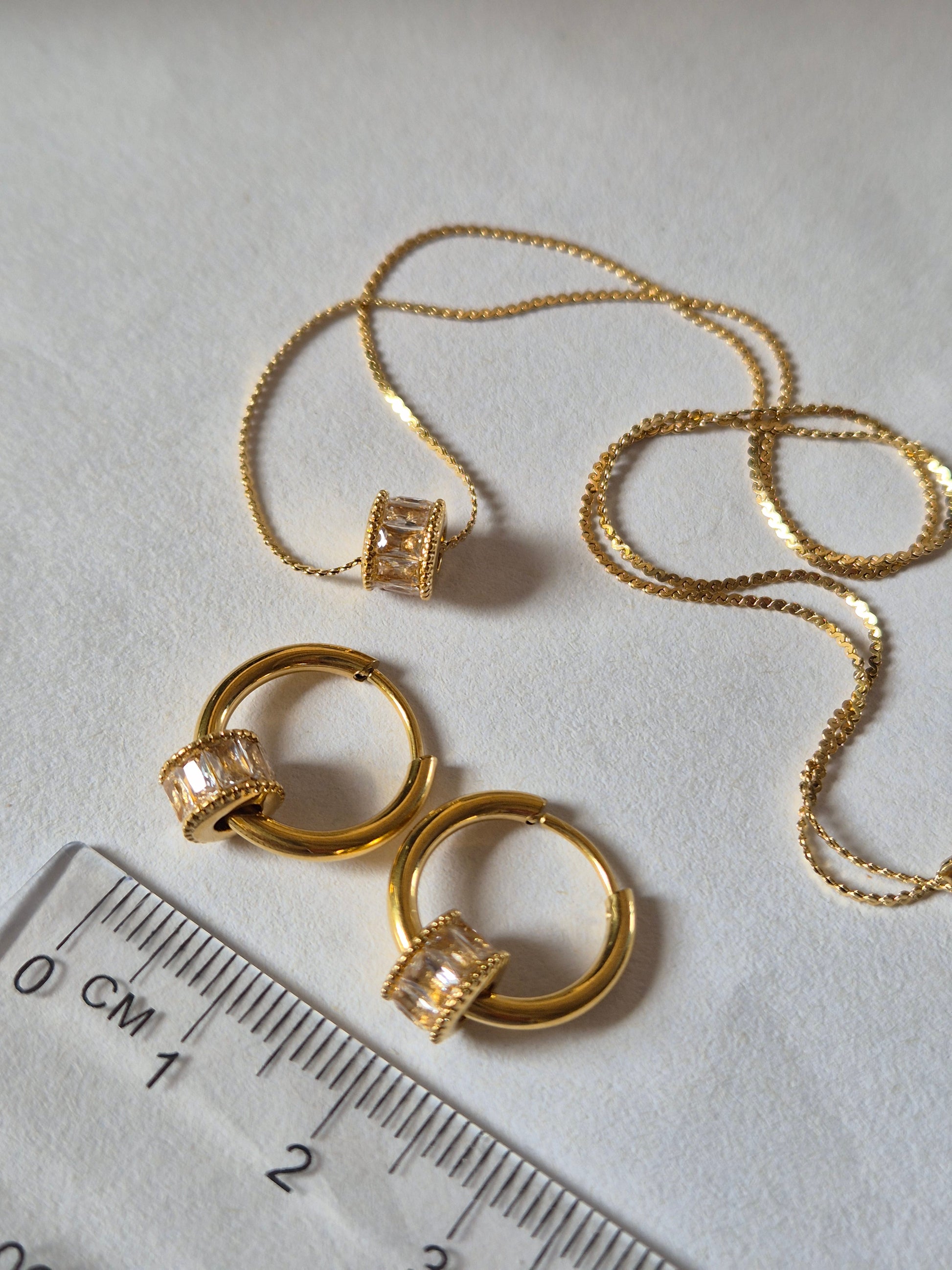 Sorella of May Celest necklace and earring set beside a ruler