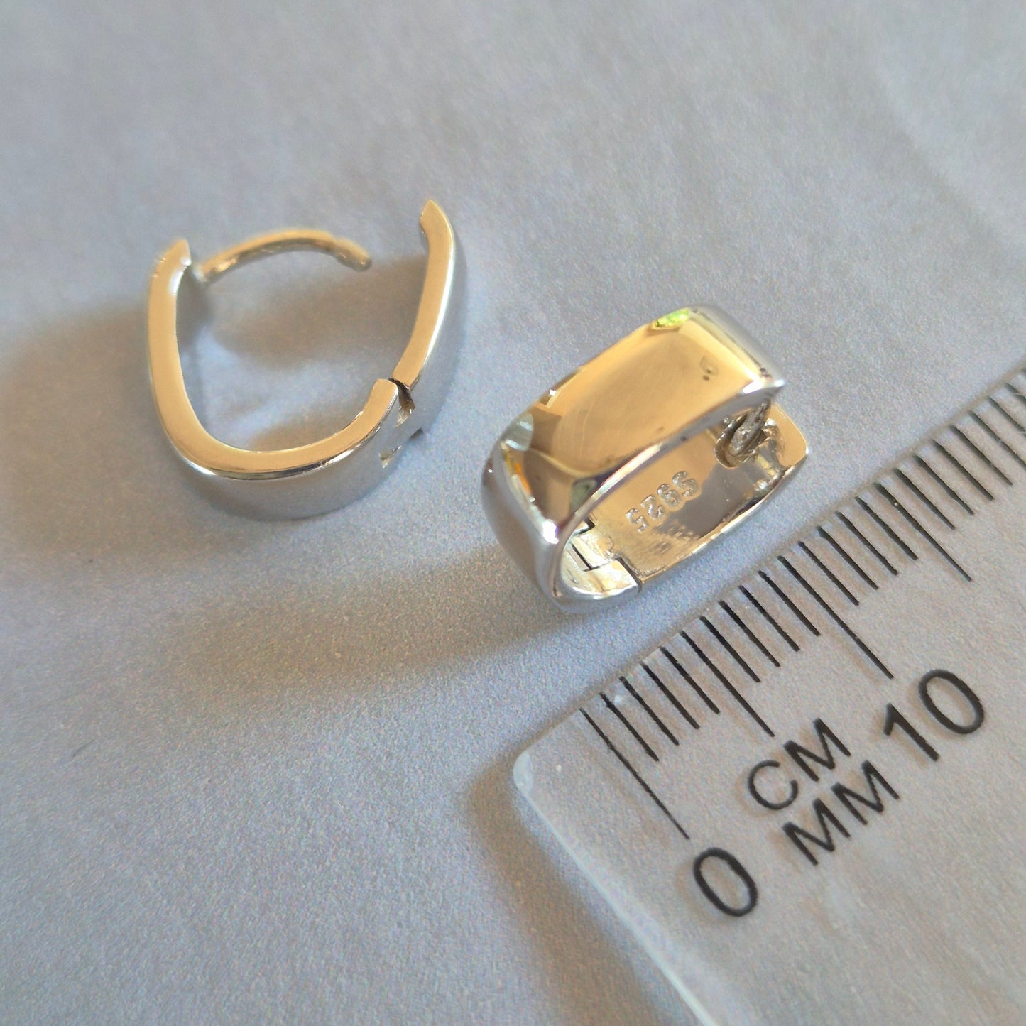 Sorella of May Sterling Silver huggie earring beside a ruler