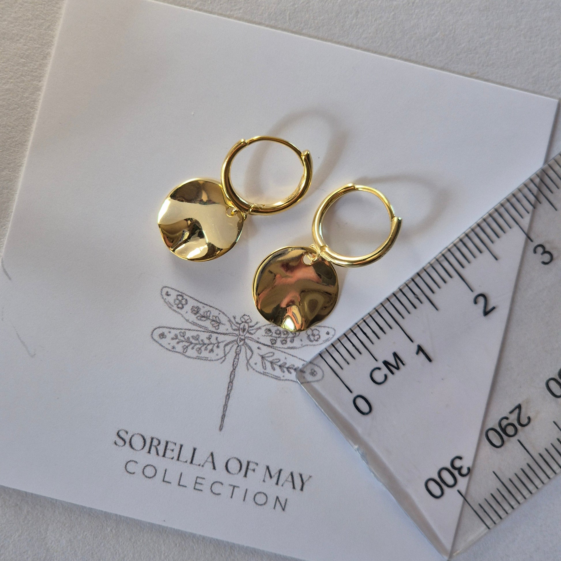 Two sterling silver gold plated earrings resting on card with a ruler showing size of earrings of 2cm long