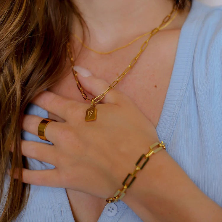 Lady with hand on chest showing Namaste Boho necklace in gold