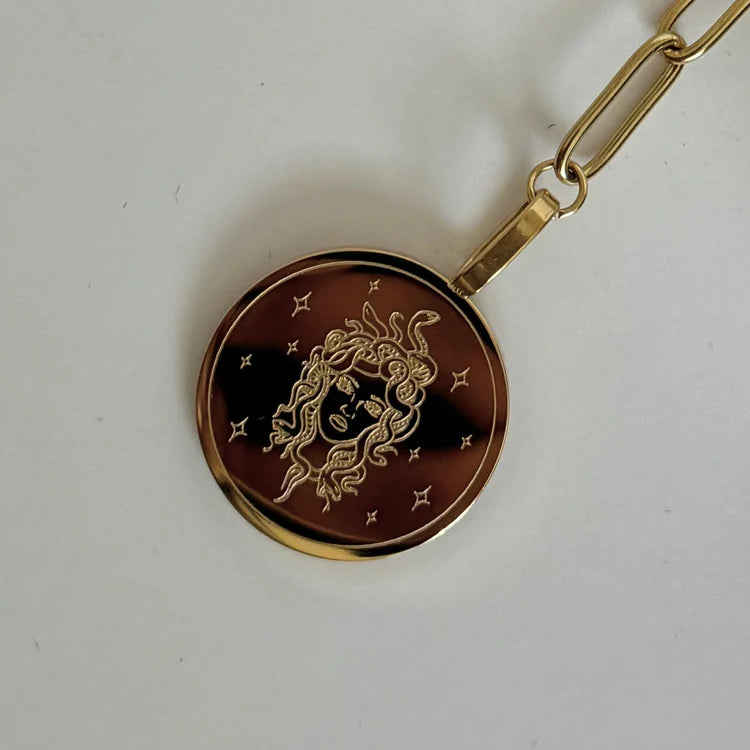 close up of the medusa pendant necklace on plain background